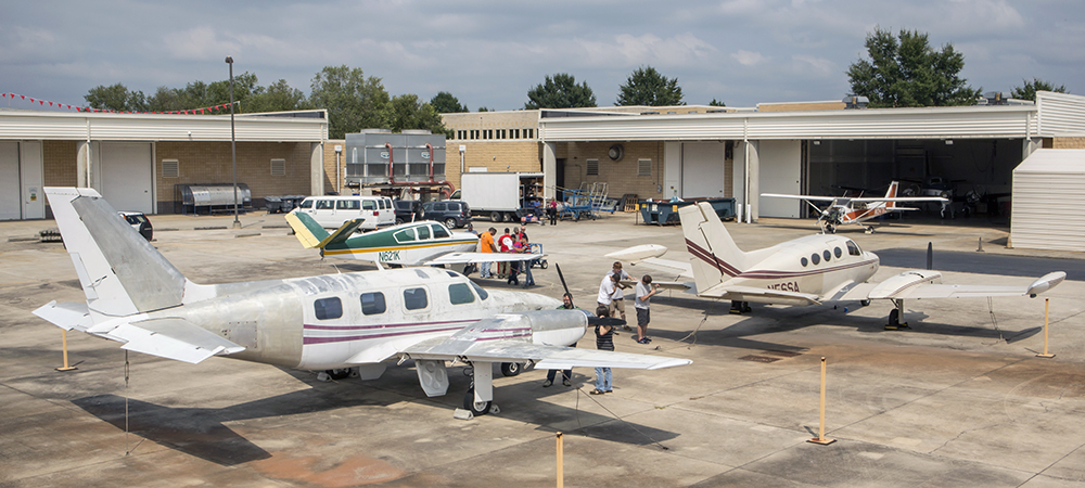 Students working on two small airplanes on the Warner Robins campus.