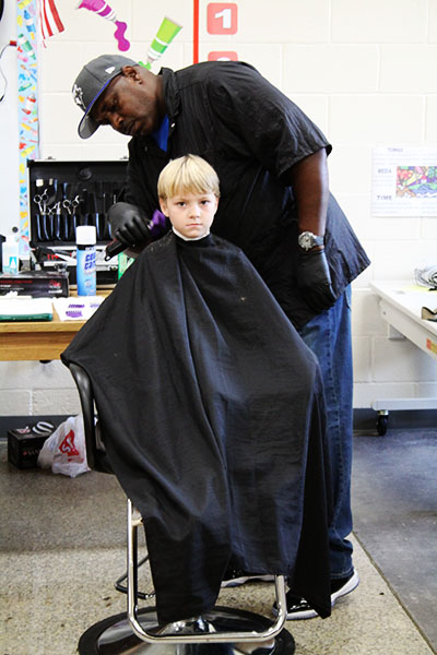 Rodney Taylor, a barbering student at CGTC cuts Nathan Stripling’s hair at the Houston County Board of Education’s 8th Annual Back2School Bash.   
