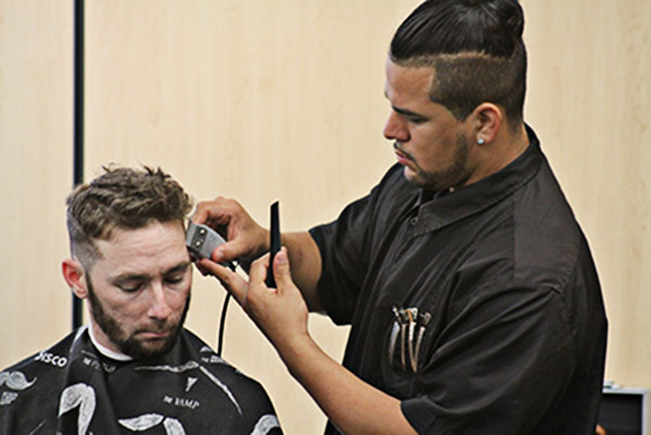 Second year Barbering student, Abraham Bonilla, trims the sideburns of retired Air Force Security Forces Craftsman, Patrick Flaherty. Flaherty visited the Center for the haircuts by CGTC students and breakfast from The Taco Shed restaurant. 