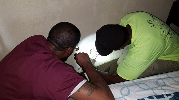 CGTC Student Ambassadors perform an electrical outlet repair inside of a room at the Home Port Macon Veterans Transition Center.