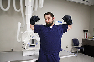 Male radiologic technology student giving a strong man pose