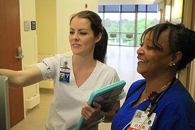 Female student nurse engages with professional nurse. 