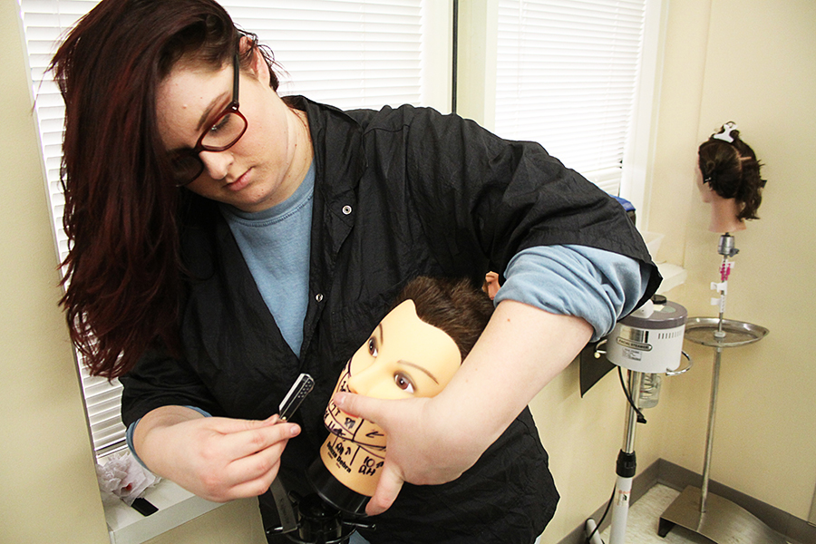 Tessa Layfield practices shaving techniques on a mannequin in the Barbering lab on CGTC’s Warner Robins campus. 
