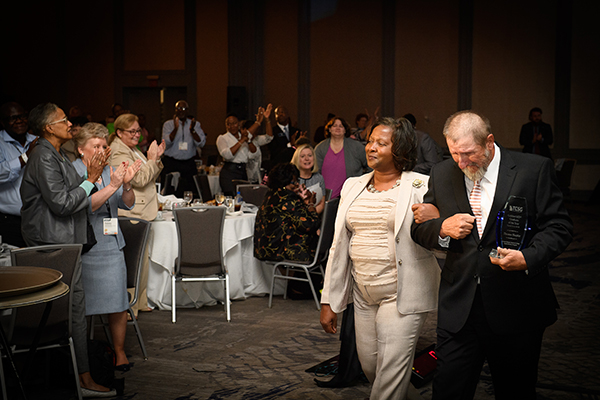 (Courtesy of TCSG)2018 Golden GED® Graduate, Thomas Shepler, walks to a standing ovation with, Dorothy Ferguson, director of Operations for the College’s Adult Education Division, following his speech at the TCSG 2018 Adult Education Fall Conference and GED® Awards. 