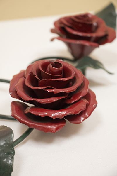 Red rose welded onto a hanging bracket. 