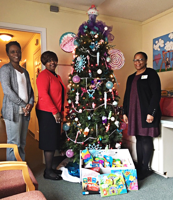(From Left to Right) Dr. Tiffany Spivey, special projects case manager at CGTC,  Ruby Holmes, project manager at CGTC, and Tanya Zellner, the executive director at Rainbow House CRC, gather next to a Christmas tree and gifts donated by CGTC’s Institutional Effectiveness staff. 
