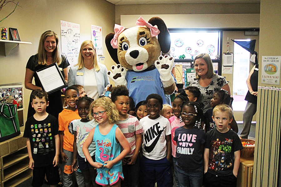 CALi, the official mascot dog of Bright from the Start: Georgia Department of Early Care and Learning (DECAL), joins leadership from the DECAL to surprise Georgia Technical College’s Larry O’Neal Child Development Center (CDC) Georgia Pre-K Program teacher, Heather Williams, (right) and her class. Williams is one of six finalists for Teacher of the Year for 2019-2020. 