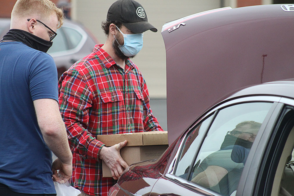 Military personnel help distribute goods at VECTR Center Veterans Appreciation Event. 