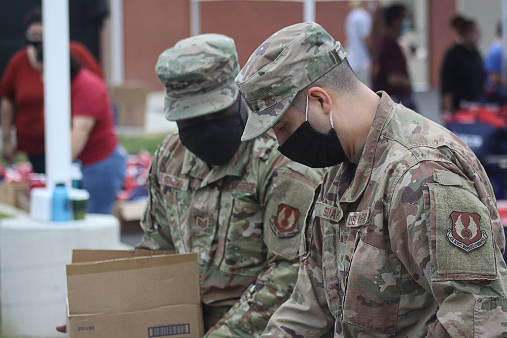 Military personnel help distribute goods at VECTR Center Veterans Appreciation Event. 