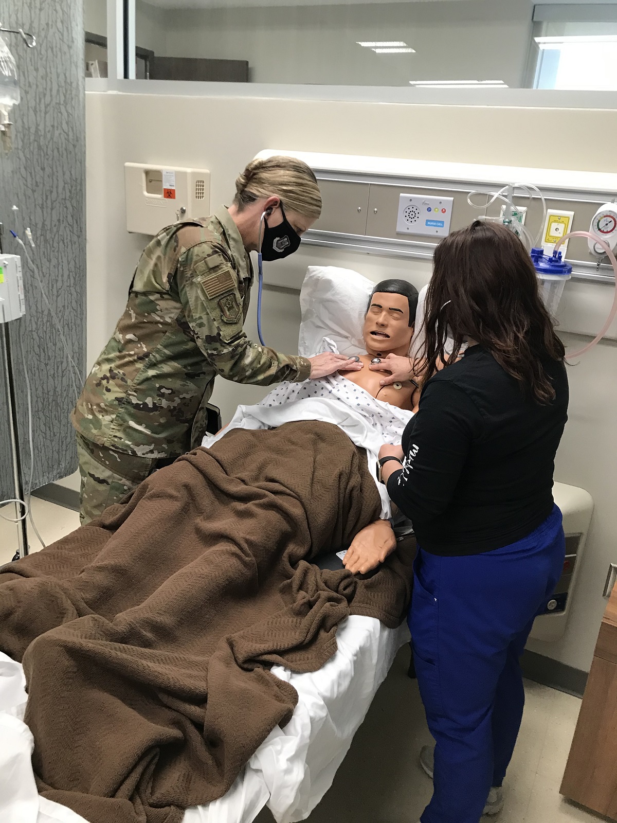 Brig. Gen. Hammerstedt listens to lung sounds next to CGTC RN Student, Michel Pickard. 