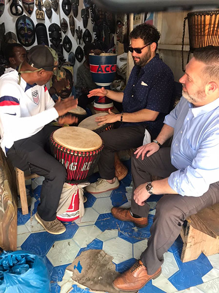 Facutly learn drumming from locals in a market.