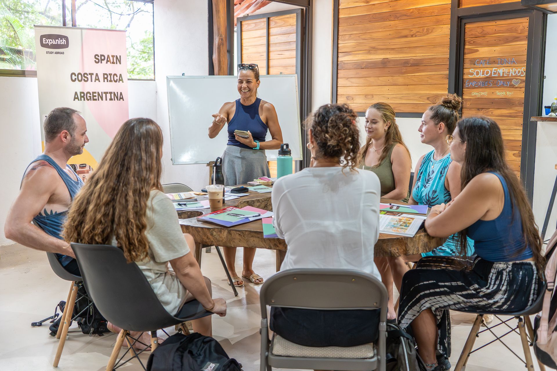 Six Students and one instructor from Expanish study abroad school having a discussion around a table in a study space.