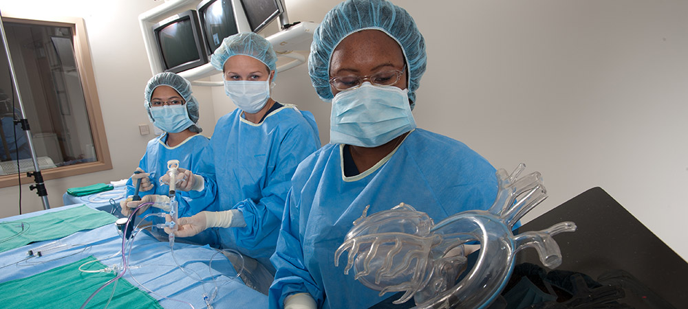 Cardiovascular Technology students wearing scrubs and handling equipment