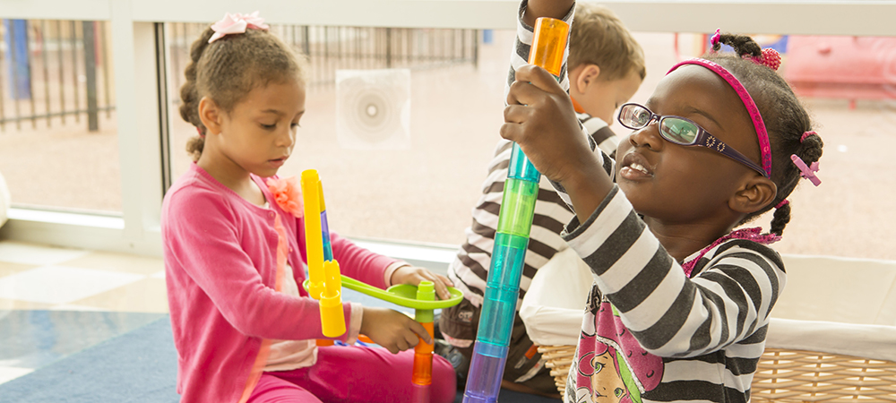 Three children playing with toys in childcare center
