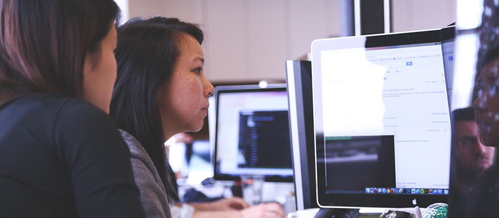 Two women looking at computer screen