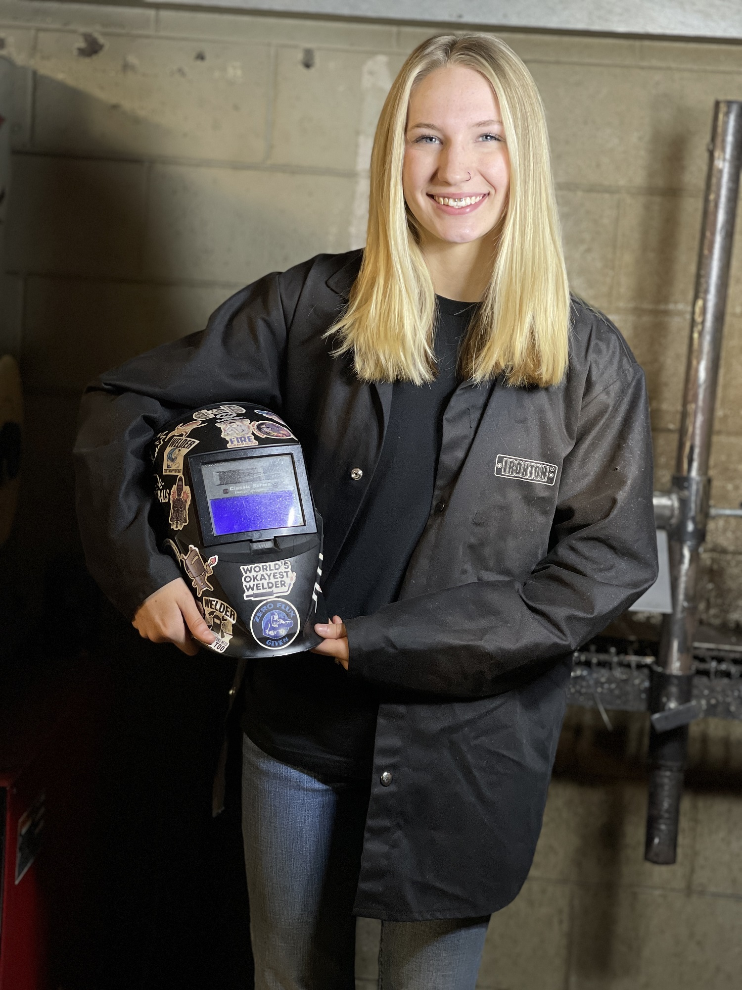 Emily Betsill stands in welding lab.